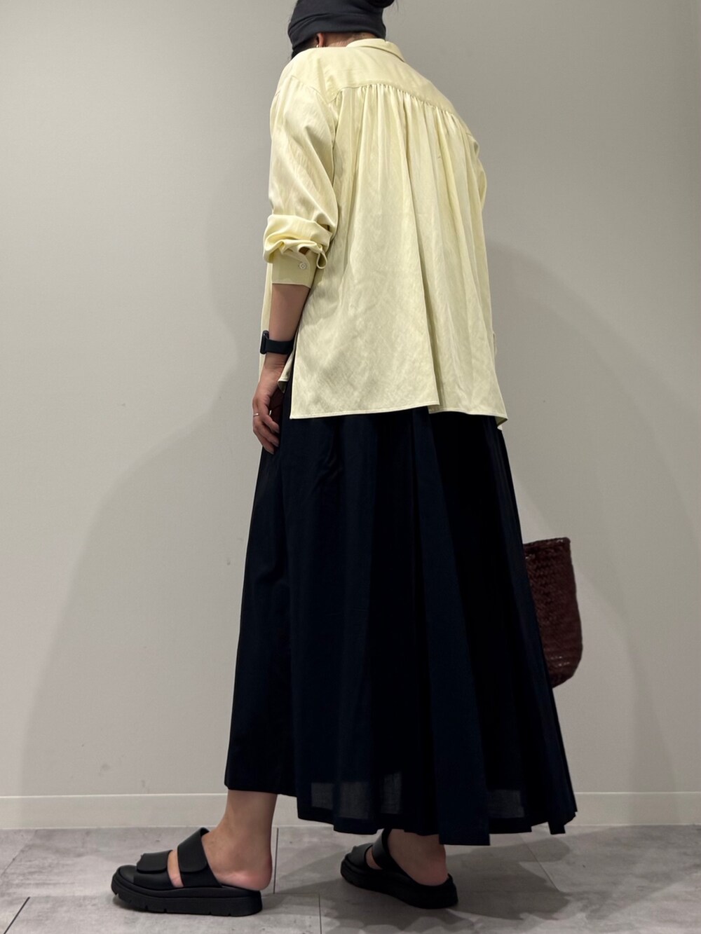 ブラウン系のトートバッグ、ブラック系のワンピース、イエロー系のシャツ/ブラウスを着用したレディースの秋コーディネートの4枚目の写真