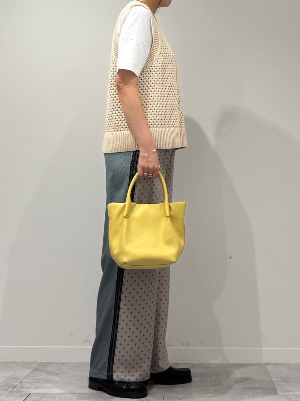 イエロー系のショルダーバッグ、ベージュ系のその他パンツ、ブラック系のローファーを着用したレディースの春コーディネートの2枚目の写真