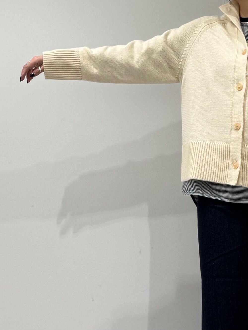 ベージュ系のボストンバッグ、ブルー系のデニムパンツ、ブラック系のローファーを着用したレディースの冬コーディネートの6枚目の写真