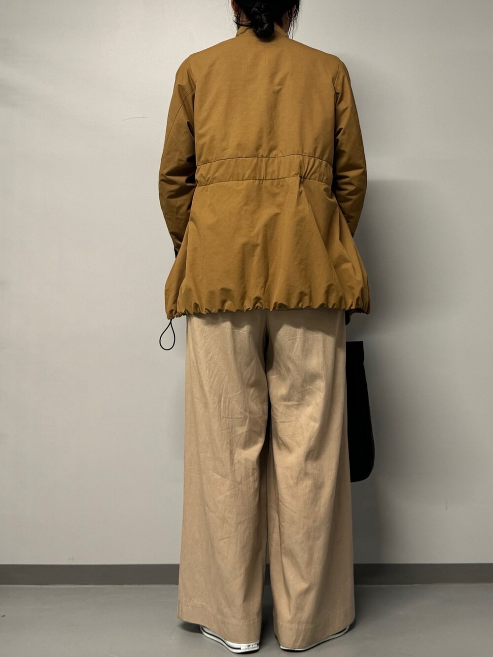 ブラック系のトートバッグ、ベージュ系のブルゾン、ブラック系のTシャツ/カットソーを着用したレディースの秋コーディネートの8枚目の写真