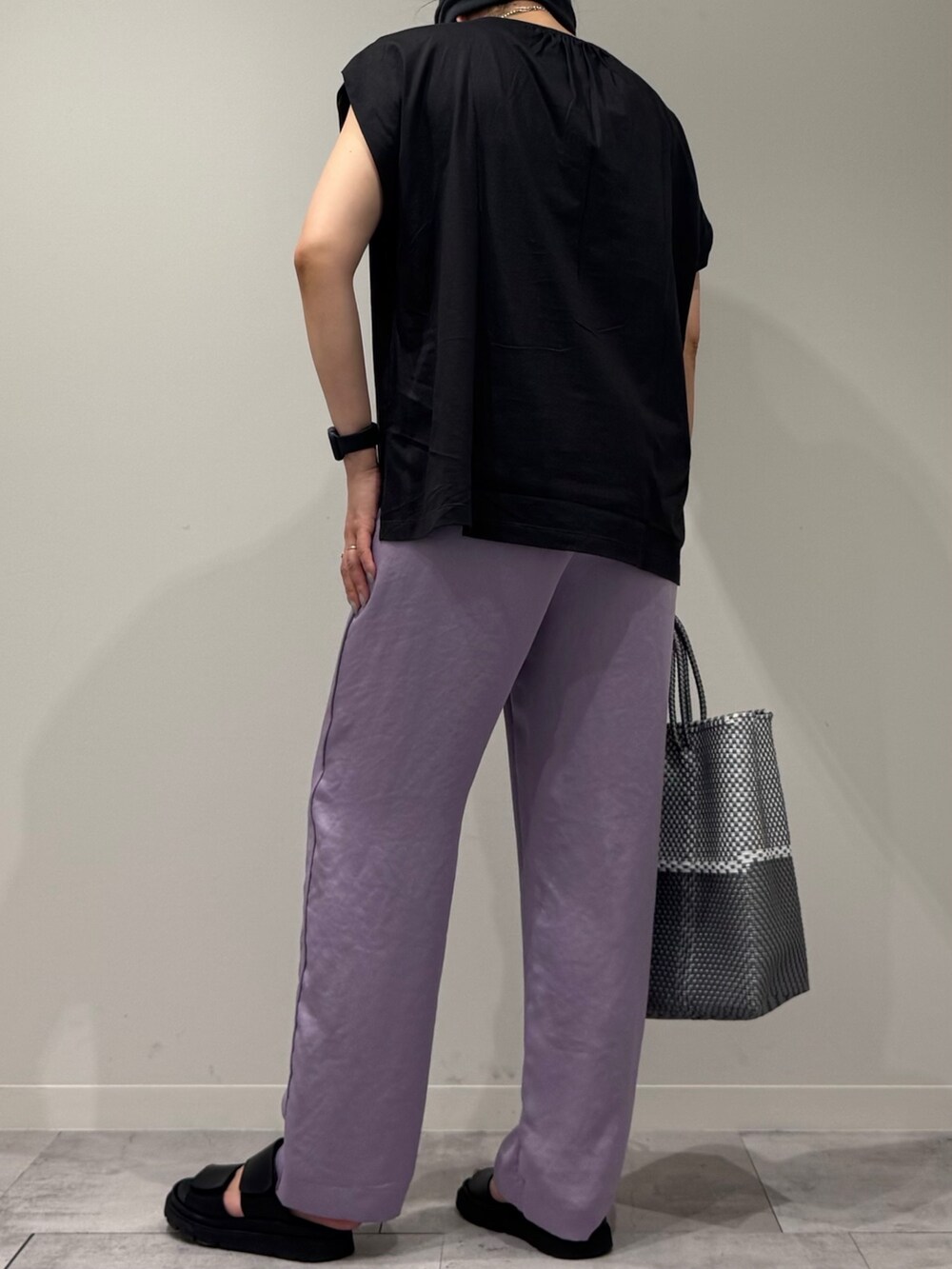 グレー系のTシャツ/カットソー、シルバー系のかごバッグ、ブラック系のサンダルを着用したレディースの夏コーディネートの4枚目の写真