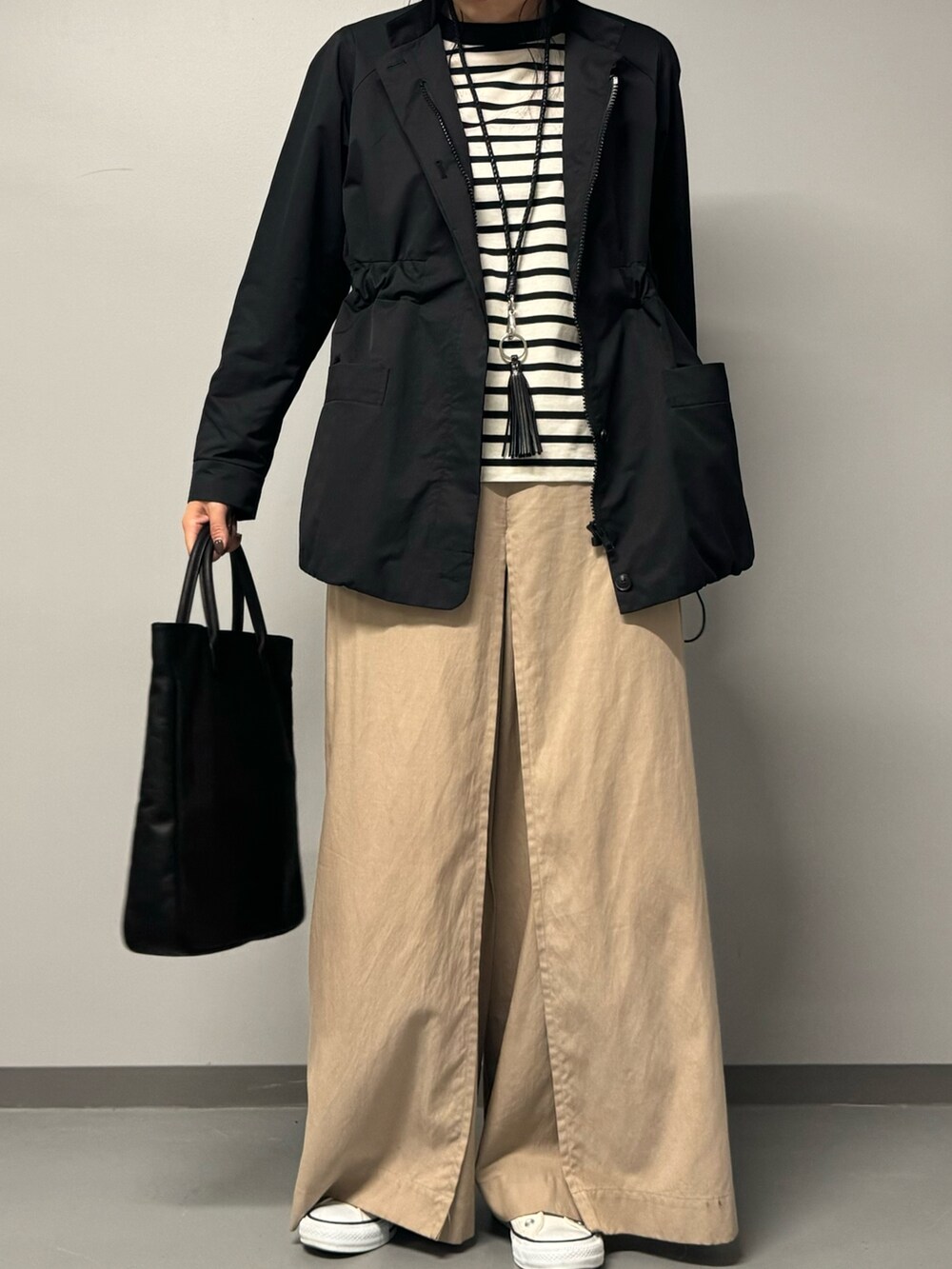 ブラック系のトートバッグ、ブラック系のブルゾン、ブラック系のTシャツ/カットソーを着用したレディースの秋コーディネートの4枚目の写真