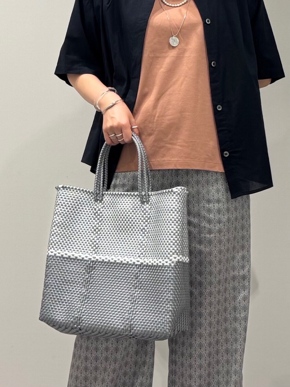 ピンク系のTシャツ/カットソー、シルバー系のかごバッグ、ベージュ系のその他パンツを着用したレディースの春コーディネートの8枚目の写真