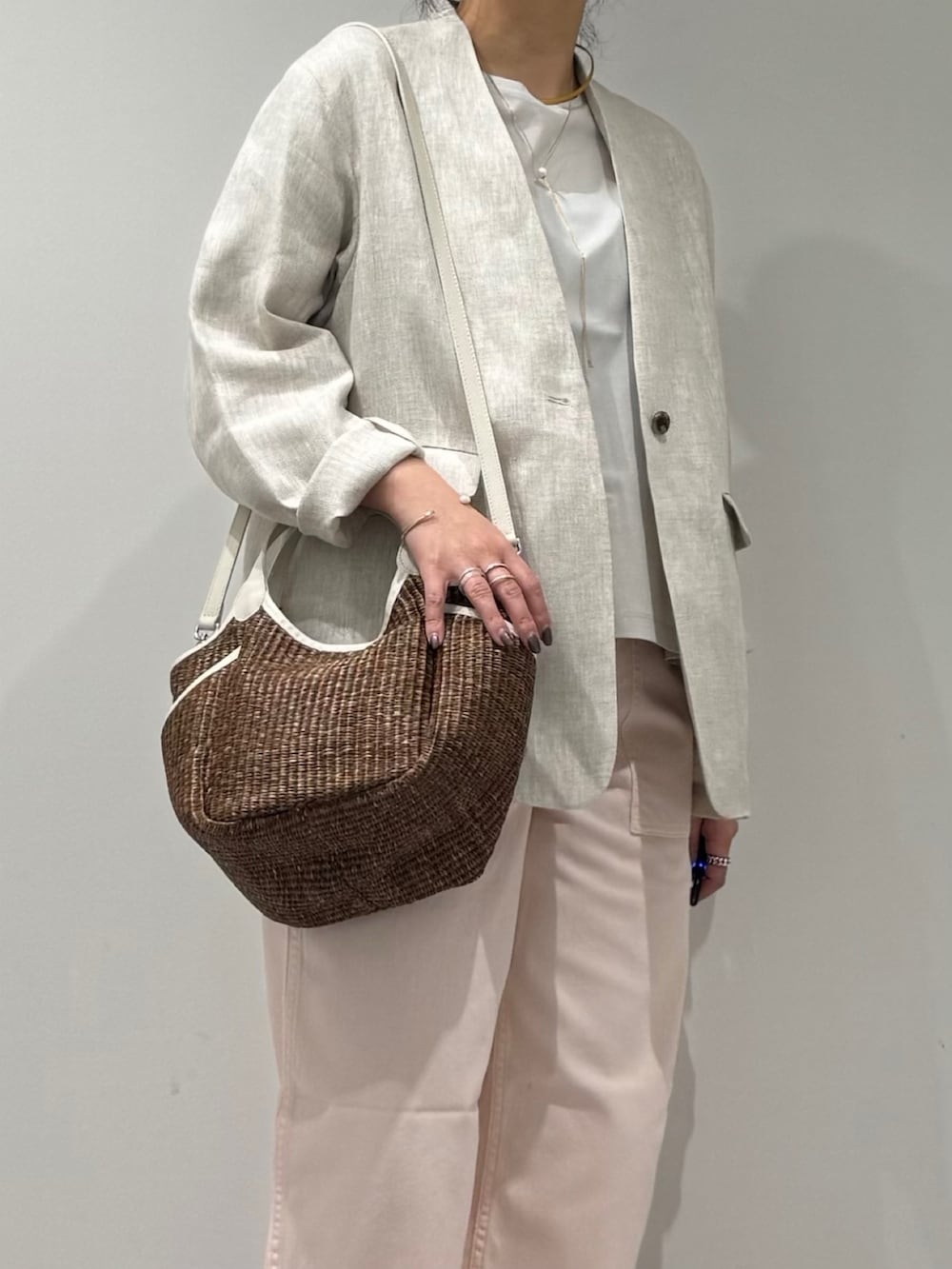 ピンク系のその他パンツ、ブラウン系のかごバッグ、ベージュ系のノーカラージャケットを着用したレディースの春コーディネートの6枚目の写真