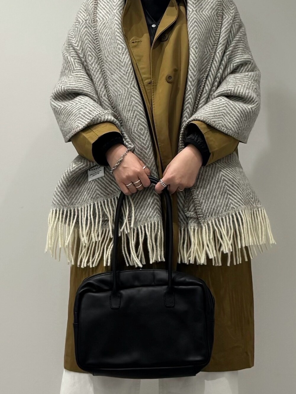 ブラック系のボストンバッグ、ベージュ系のダウンジャケット/コート、ホワイト系のデニムパンツを着用したレディースの冬コーディネートの6枚目の写真