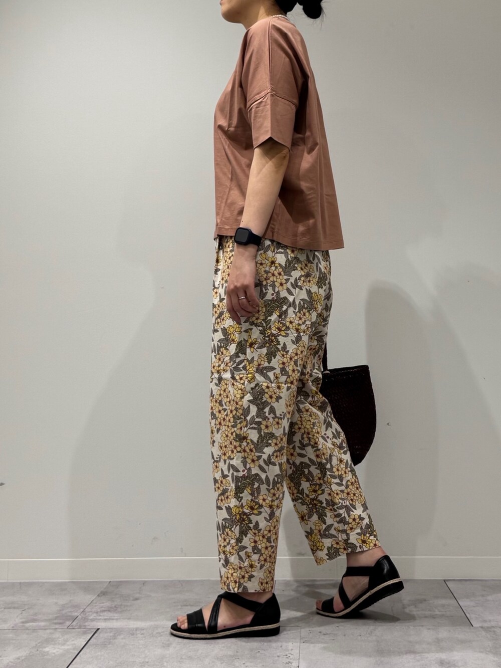ブラウン系のトートバッグ、イエロー系のその他パンツ、ブラック系のサンダルを着用したレディースの春コーディネートの6枚目の写真