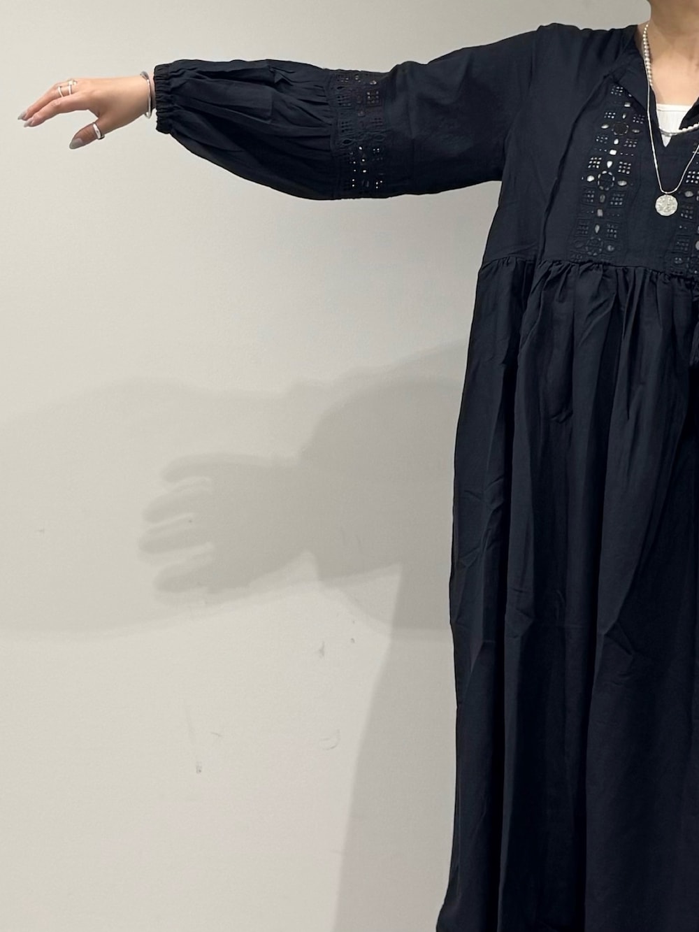 ブラック系のワンピース、シルバー系のかごバッグ、ブラック系のサンダルを着用したレディースの秋コーディネートの8枚目の写真