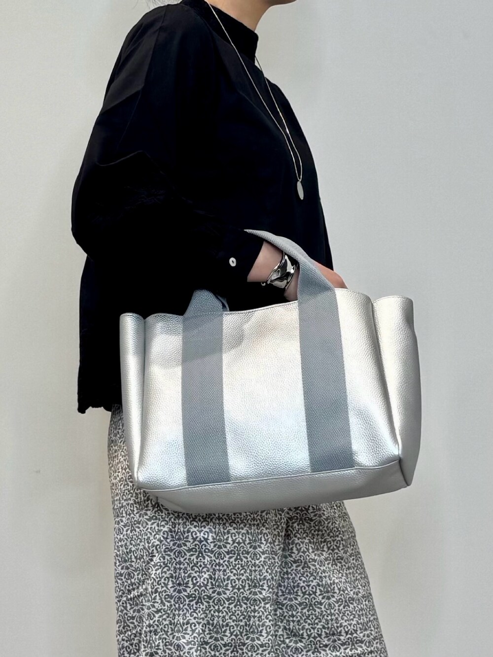 ブラック系のシャツ/ブラウス、シルバー系のトートバッグ、ブラック系のその他パンツを着用したレディースの秋コーディネートの6枚目の写真