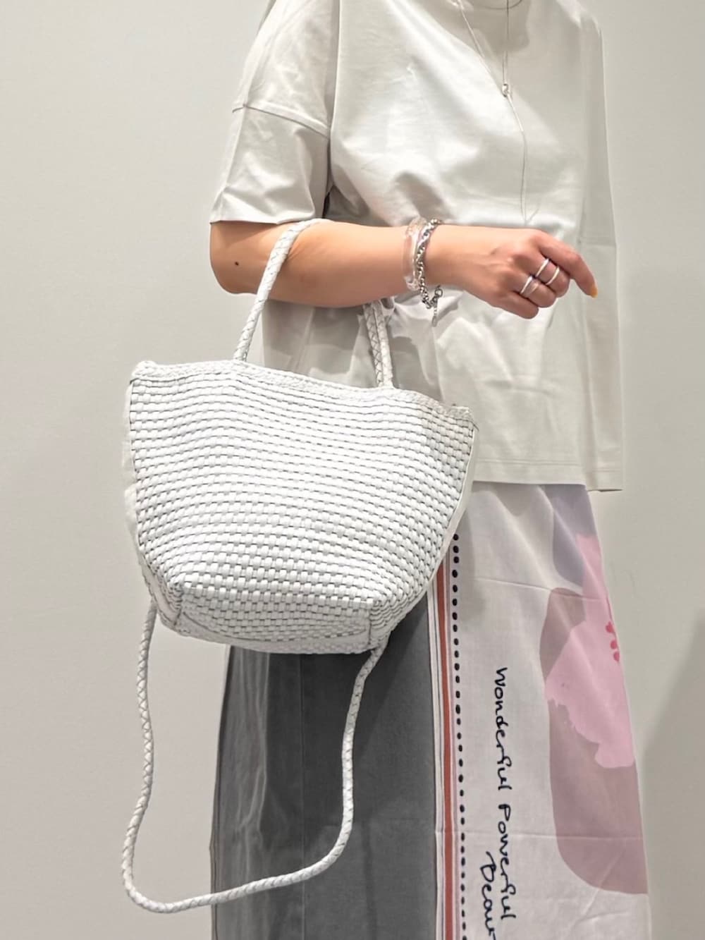 ホワイト系のトートバッグ、ブラック系のサンダル、グレー系のデニムパンツを着用したレディースの春コーディネートの7枚目の写真