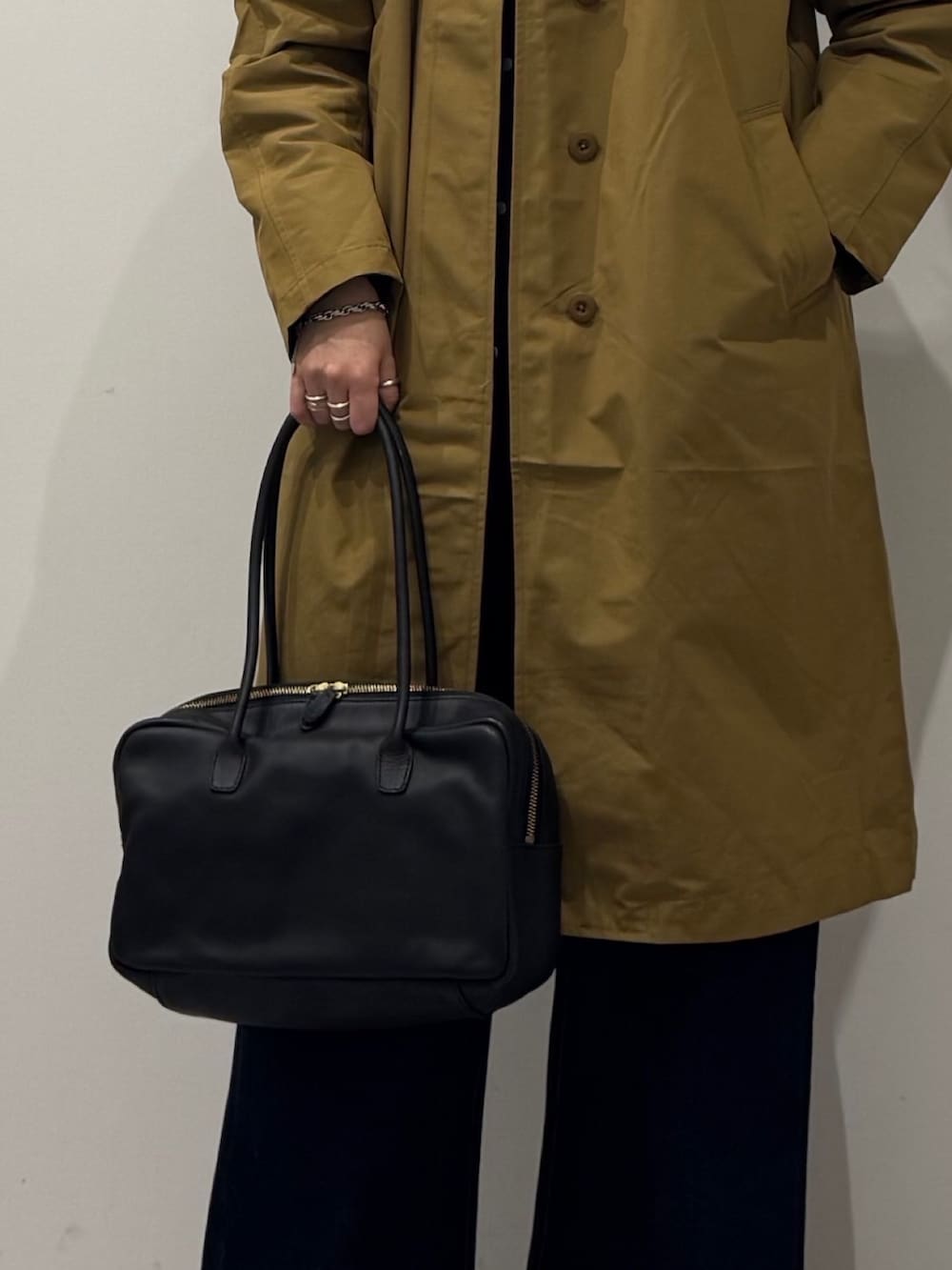 ブラック系のボストンバッグ、ベージュ系のダウンジャケット/コート、ブルー系のデニムパンツを着用したレディースの冬コーディネートの8枚目の写真