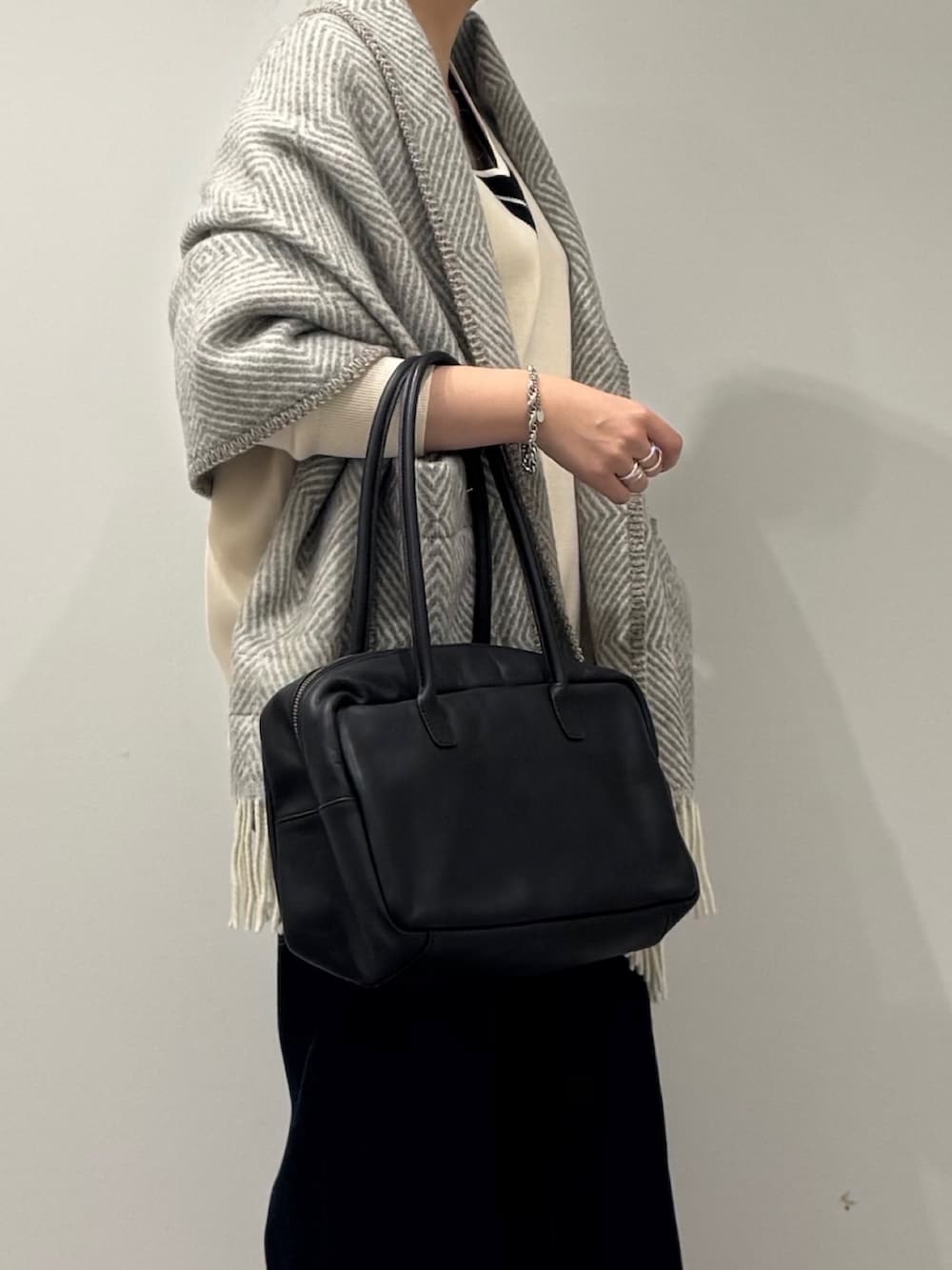 ブラック系のボストンバッグ、ブルー系のデニムパンツ、ブラック系のローファーを着用したレディースの冬コーディネートの8枚目の写真