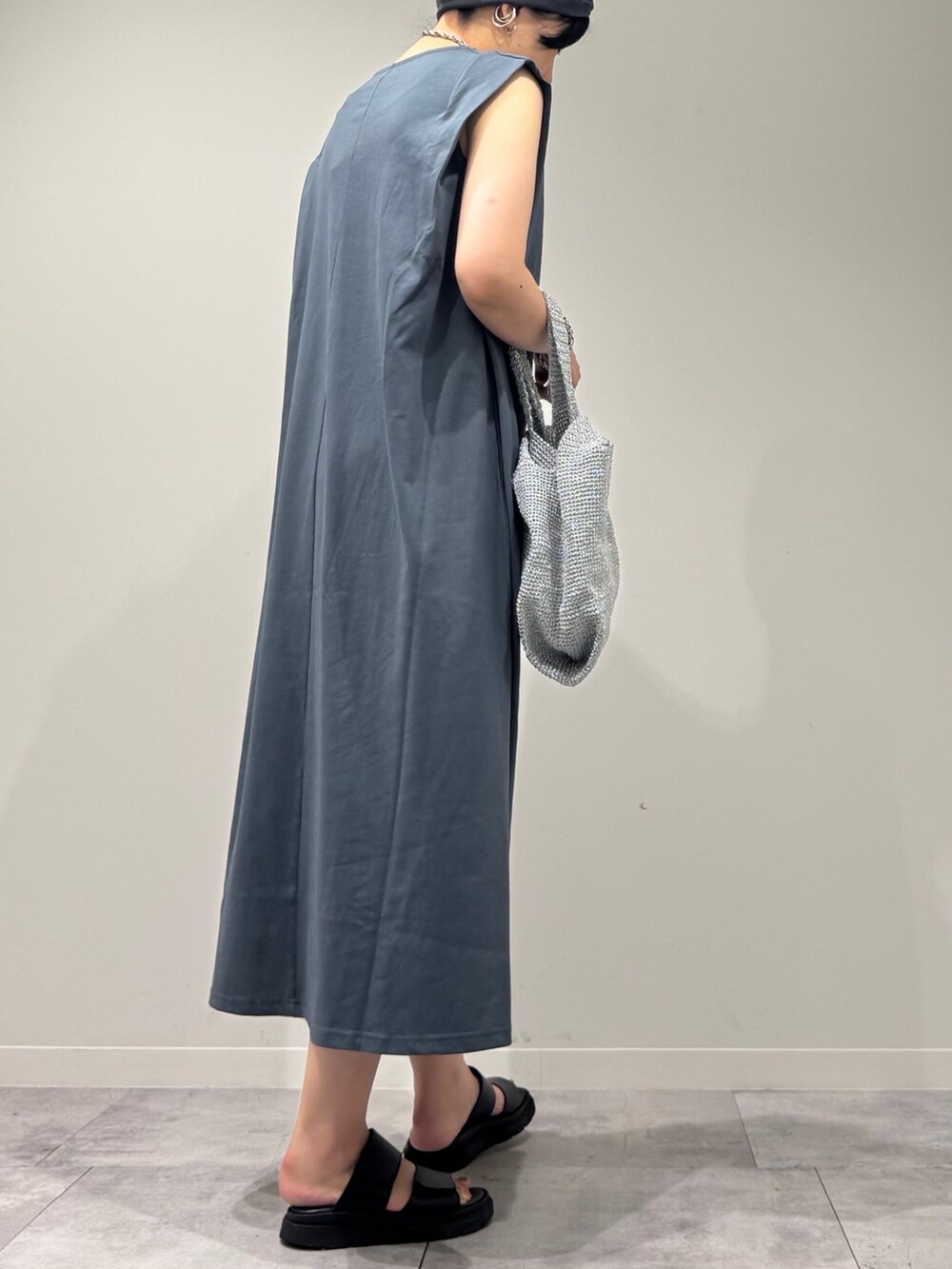 シルバー系のかごバッグ、ブラック系のサンダル、ブルー系のワンピースを着用したレディースの夏コーディネートの3枚目の写真