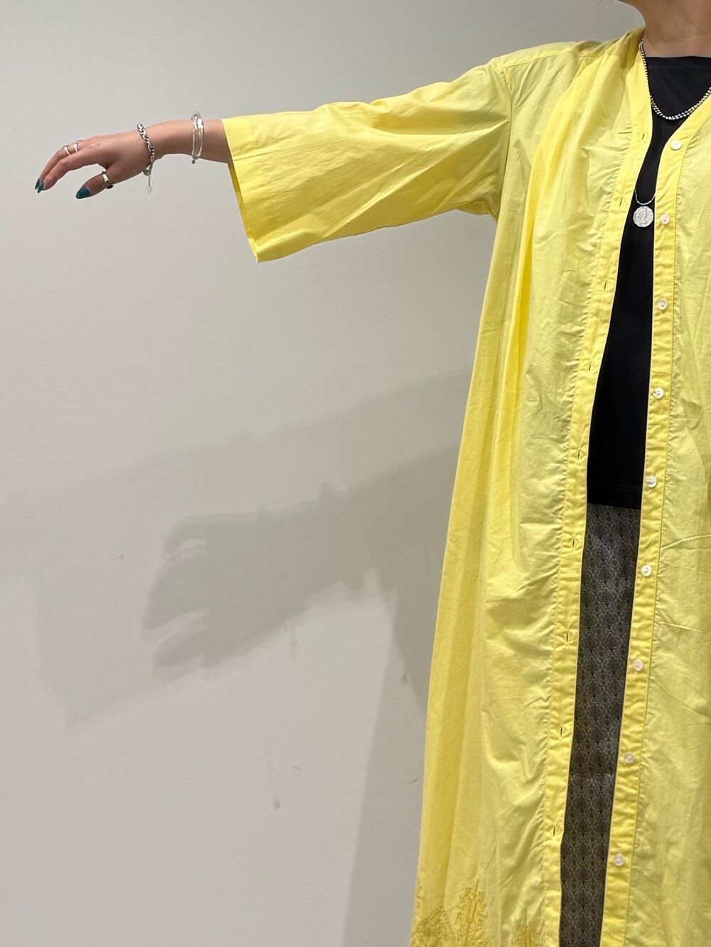 ホワイト系のかごバッグ、イエロー系のワンピース、ベージュ系のその他パンツを着用したレディースの夏コーディネートの7枚目の写真