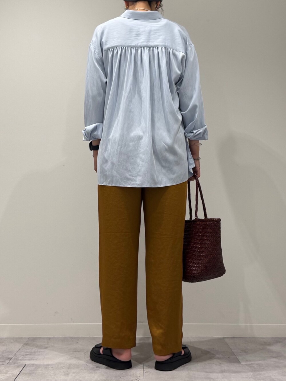 ブラウン系のトートバッグ、ブラウン系のその他パンツ、ブラック系のサンダルを着用したレディースの秋コーディネートの4枚目の写真