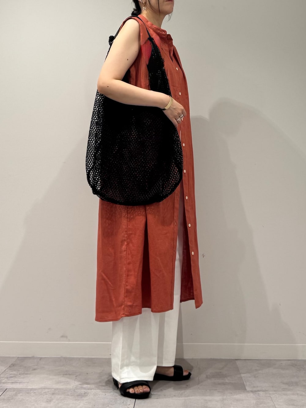 レッド系のワンピース、ホワイト系のデニムパンツ、ブラック系のサンダルを着用したレディースの夏コーディネートの6枚目の写真