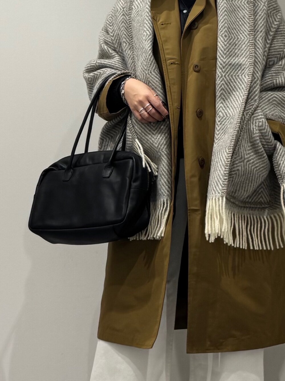 ブラック系のボストンバッグ、ベージュ系のダウンジャケット/コート、ホワイト系のデニムパンツを着用したレディースの冬コーディネートの7枚目の写真