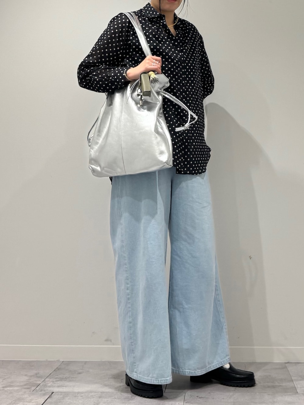シルバー系のトートバッグ、ブラック系のローファー、ブラック系のシャツ/ブラウスを着用したレディースの春コーディネートの2枚目の写真