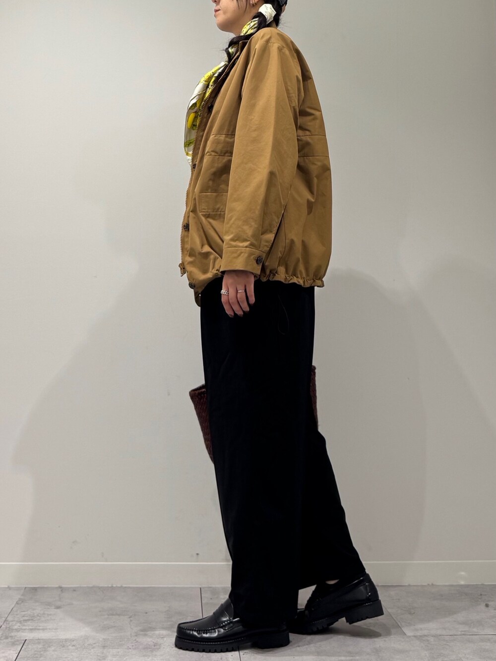 ブラウン系のトートバッグ、ブラック系のサロペット/オーバーオール、ブラック系のローファーを着用したレディースの秋コーディネートの5枚目の写真