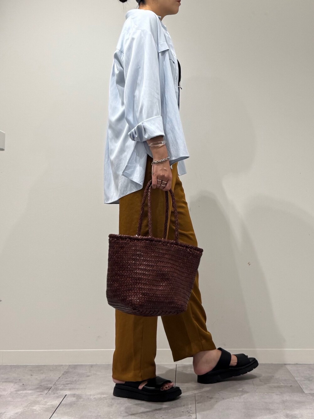 ブラウン系のトートバッグ、ブラウン系のその他パンツ、ブラック系のサンダルを着用したレディースの秋コーディネートの3枚目の写真