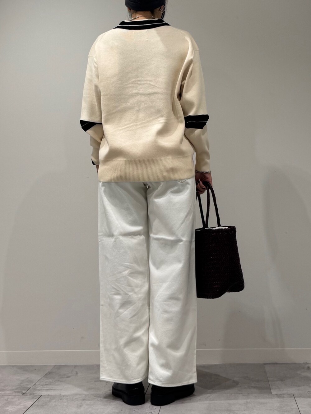 パープル系のトートバッグ、ホワイト系のデニムパンツ、ブラック系のローファーを着用したレディースの冬コーディネートの4枚目の写真