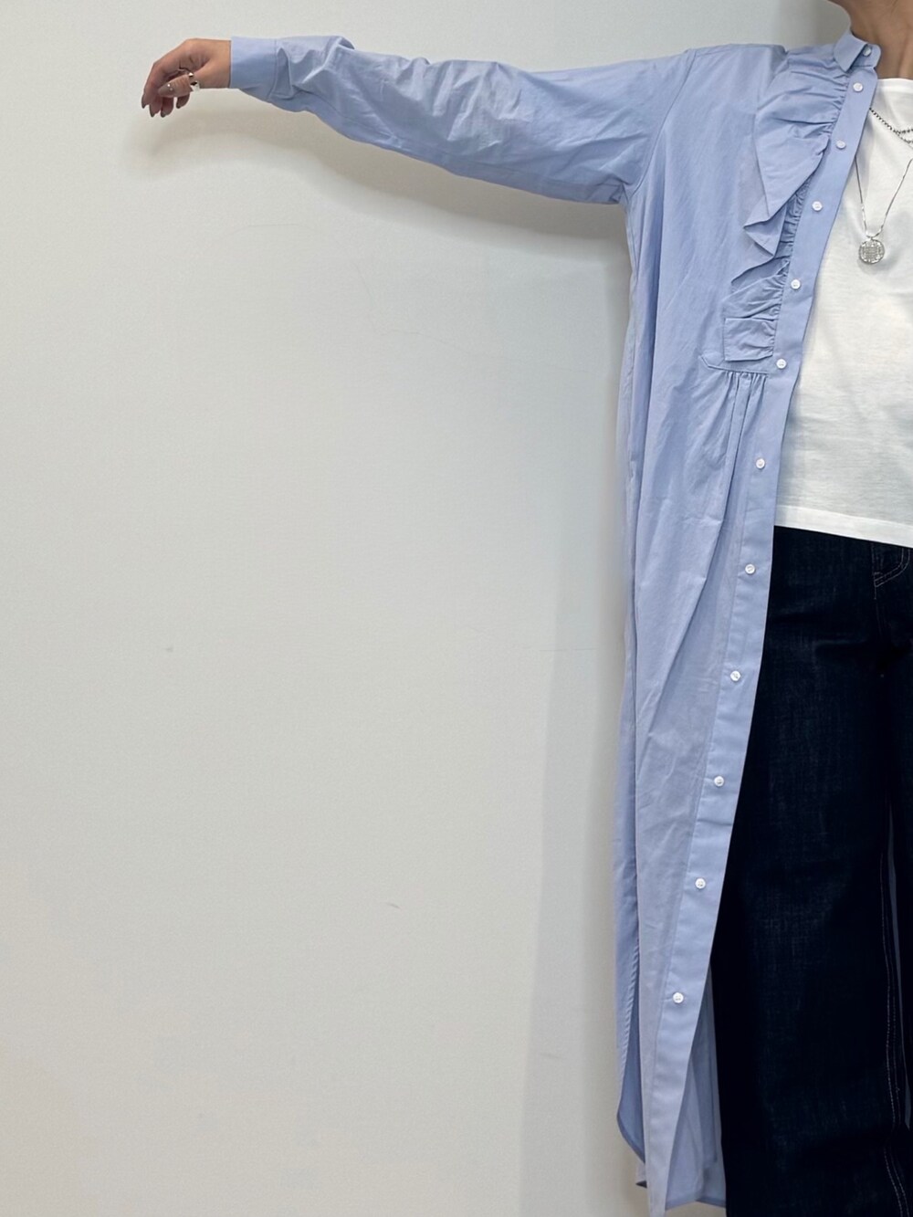 ブルー系のシャツワンピース、シルバー系のかごバッグ、ブルー系のデニムパンツを着用したレディースの春コーディネートの8枚目の写真