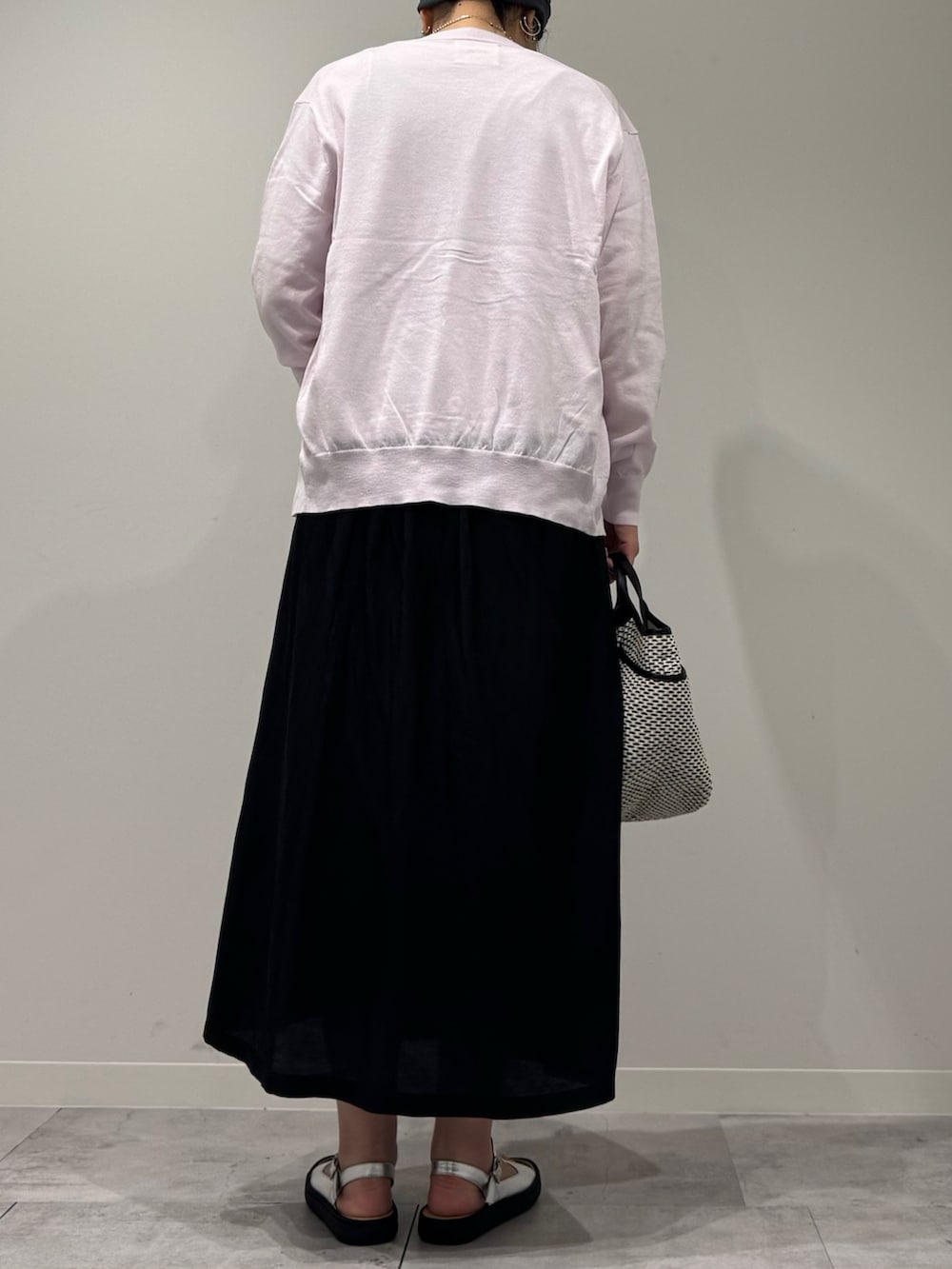 ブラック系のかごバッグ、ピンク系のカーディガン/ボレロ、ホワイト系のTシャツ/カットソーを着用したレディースの春コーディネートの4枚目の写真