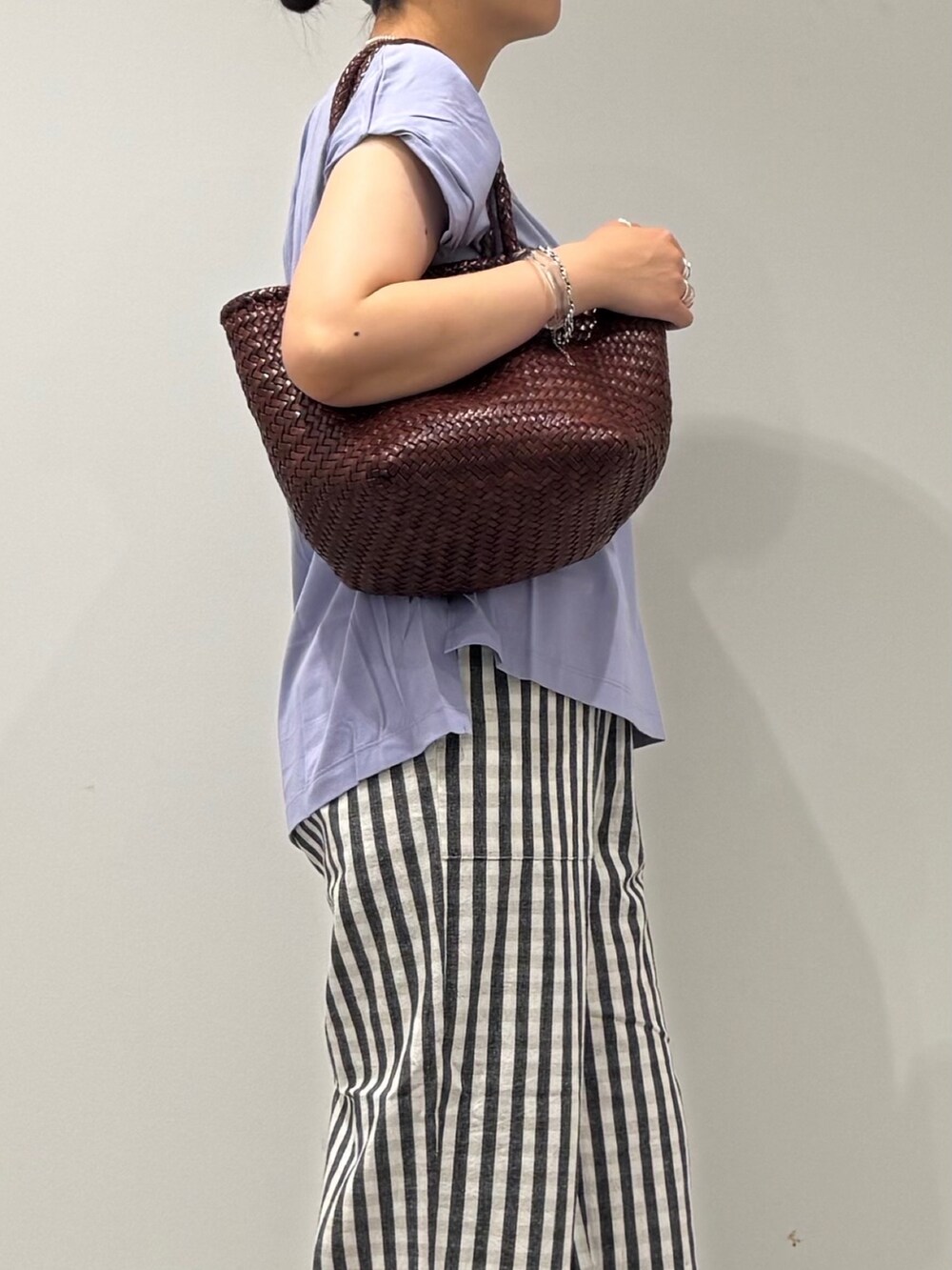 ブラウン系のトートバッグ、ブラック系のその他パンツ、ブラック系のサンダルを着用したレディースの秋コーディネートの7枚目の写真