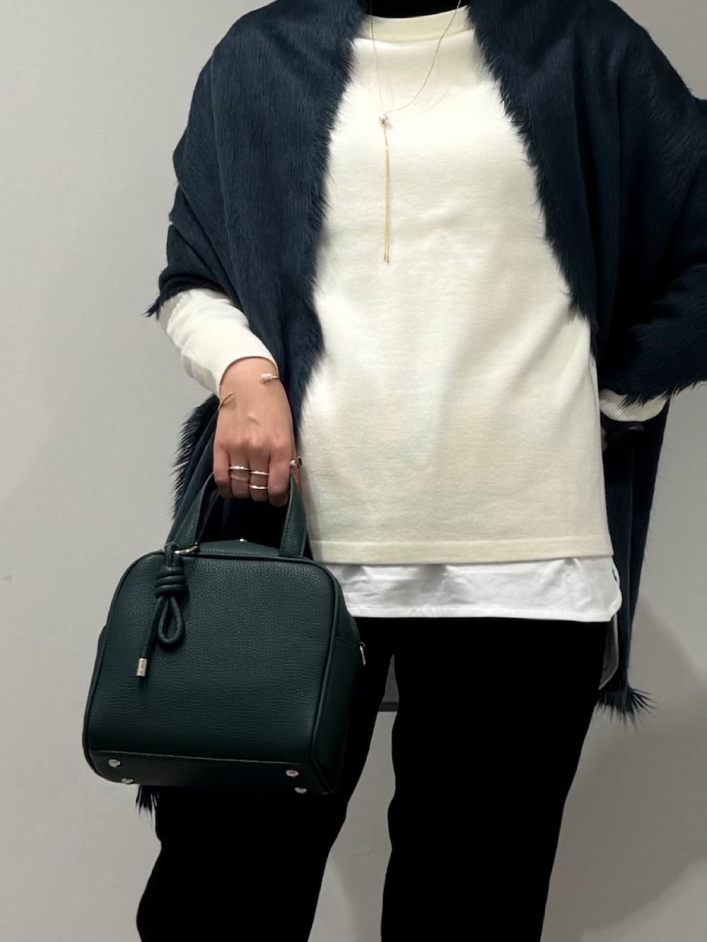 グリーン系のボストンバッグ、ブラック系のその他パンツ、ブラック系のローファーを着用したレディースの冬コーディネートの7枚目の写真