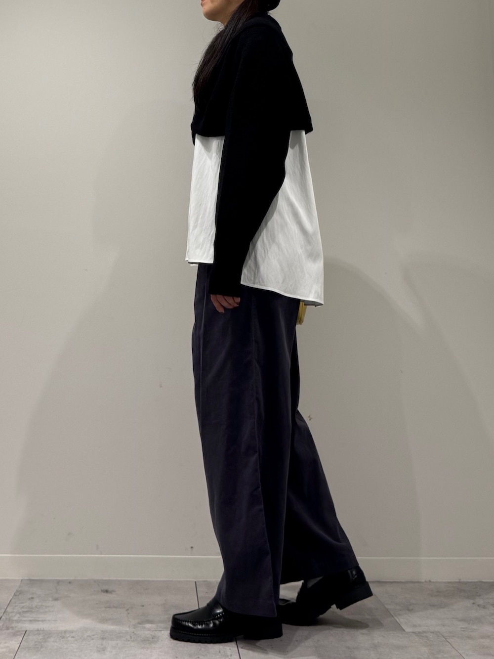 イエロー系のボストンバッグ、ブラック系のローファー、ホワイト系のシャツ/ブラウスを着用したレディースの冬コーディネートの5枚目の写真