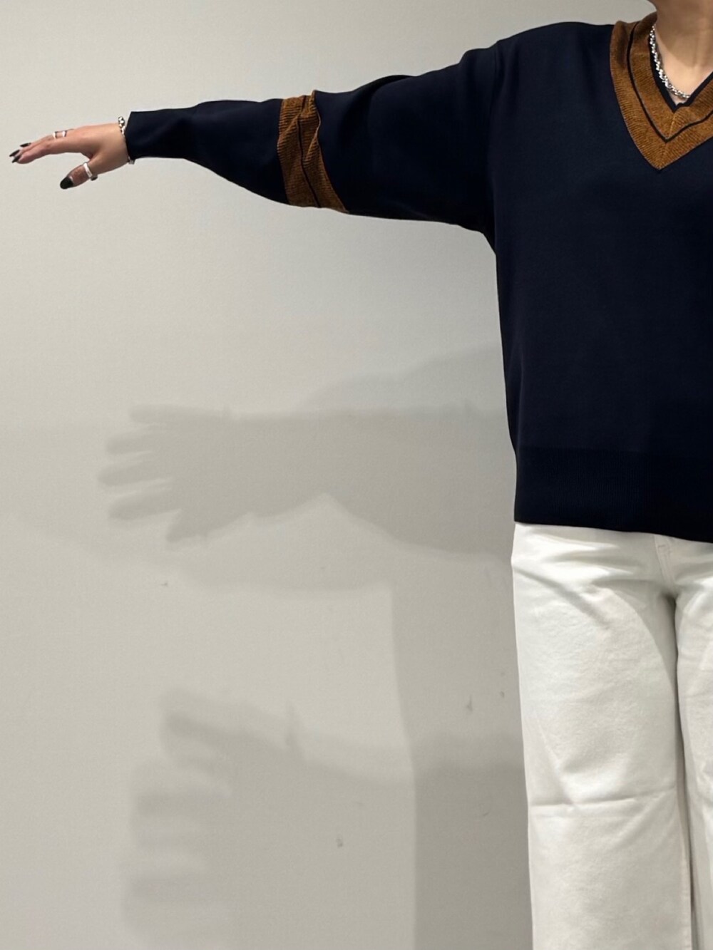 ブラック系のボストンバッグ、ホワイト系のデニムパンツ、ブラック系のローファーを着用したレディースの冬コーディネートの6枚目の写真