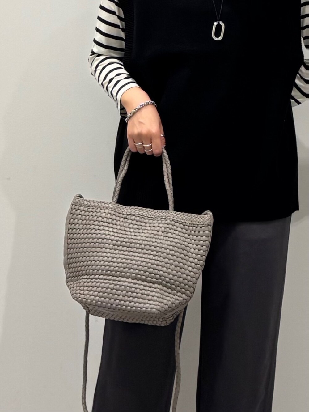 ベージュ系のトートバッグ、ブラック系のその他パンツ、ブラック系のTシャツ/カットソーを着用したレディースの秋コーディネートの8枚目の写真