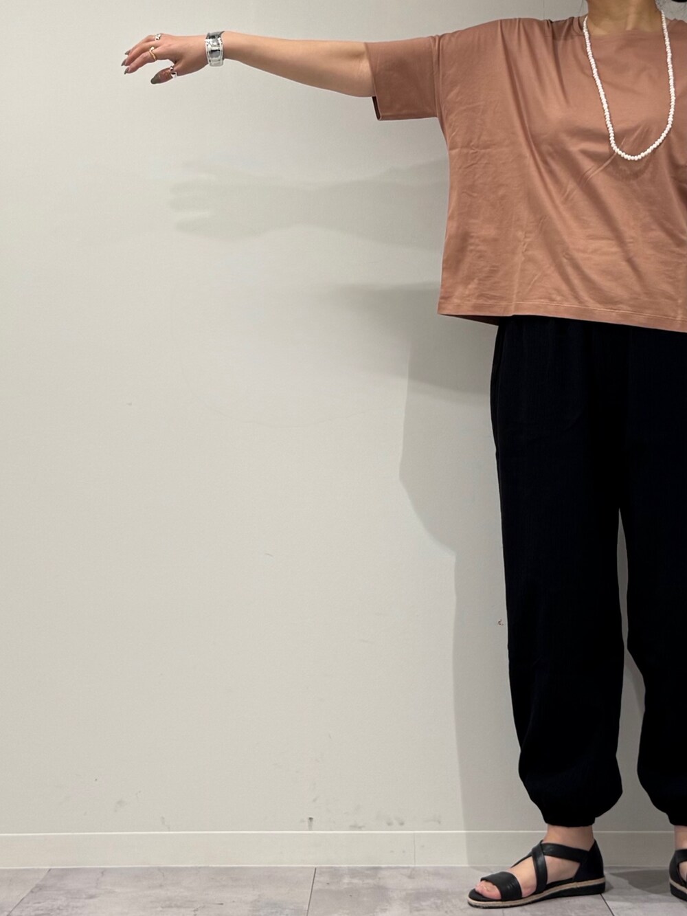 シルバー系のかごバッグ、ブラック系のサンダル、ゴールド系のネックレスを着用したレディースの春コーディネートの7枚目の写真