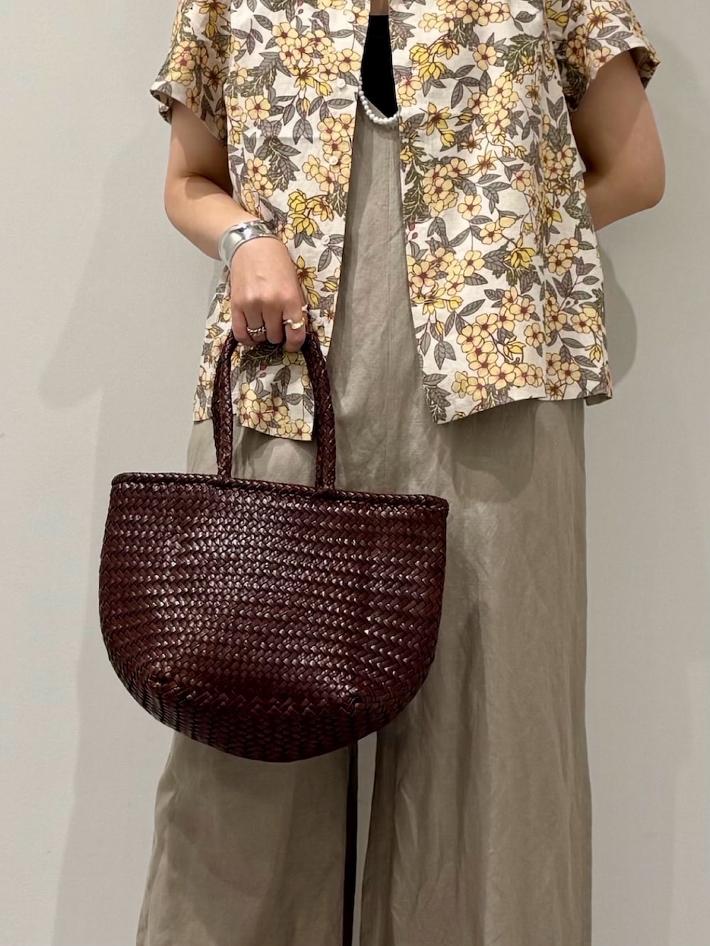 ブラウン系のトートバッグ、ベージュ系のサロペット/オーバーオール、ブラック系のサンダルを着用したレディースの春コーディネートの9枚目の写真