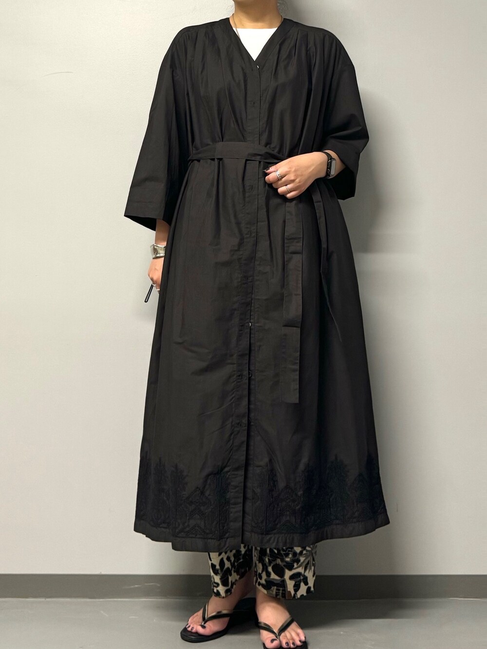 ブラック系のワンピース、ブラック系のサンダル、ホワイト系のTシャツ/カットソーを着用したレディースの夏コーディネートの3枚目の写真