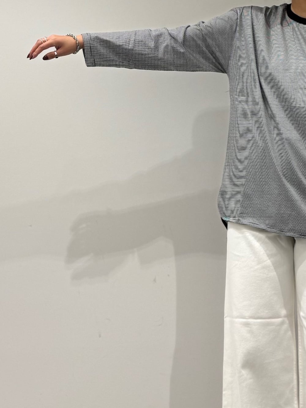 ブラウン系のトートバッグ、ホワイト系のデニムパンツ、ブラック系のローファーを着用したレディースの秋コーディネートの6枚目の写真