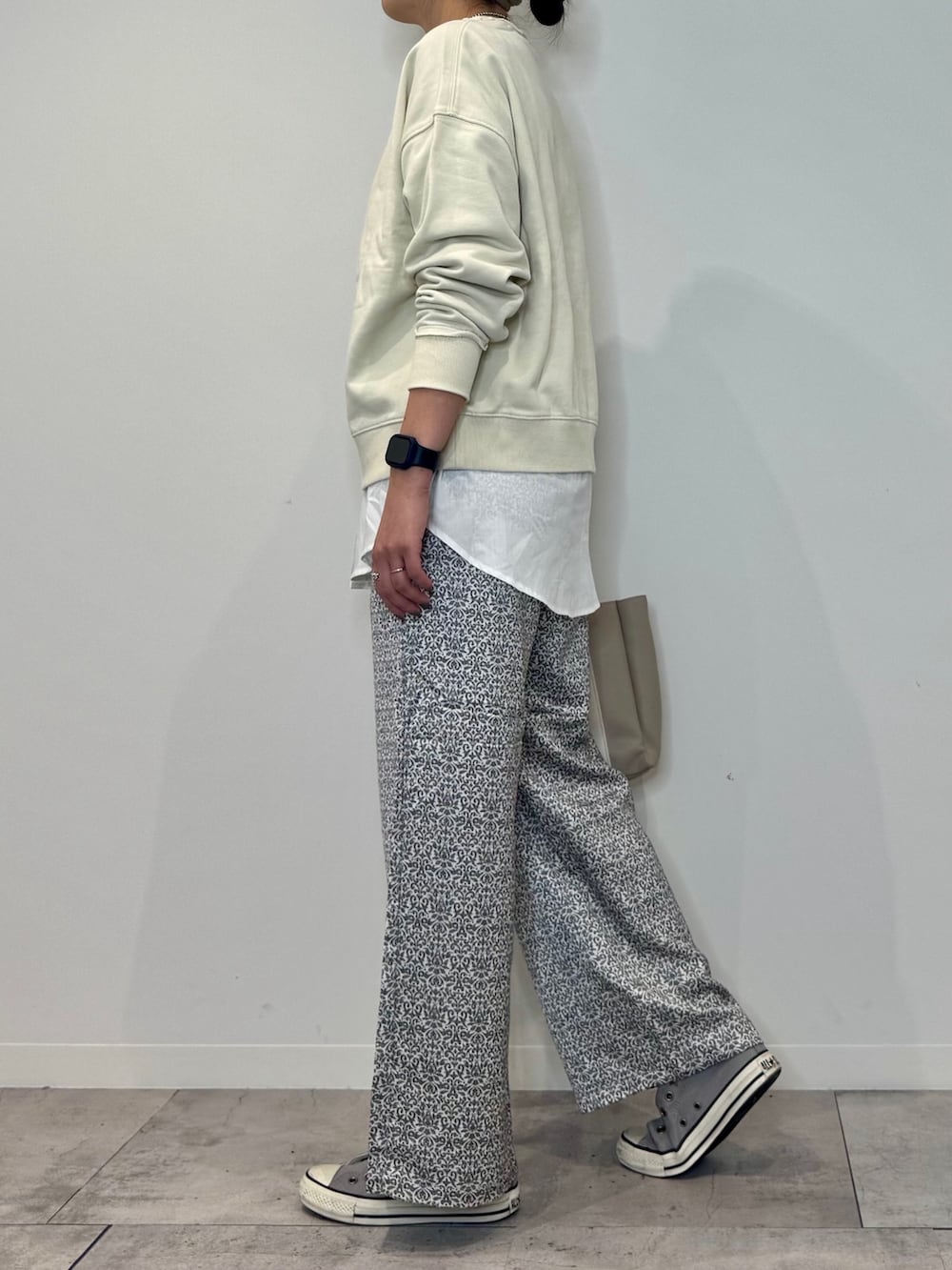 ホワイト系のスウェット、ベージュ系のトートバッグ、ブラック系のその他パンツを着用したレディースの秋コーディネートの6枚目の写真