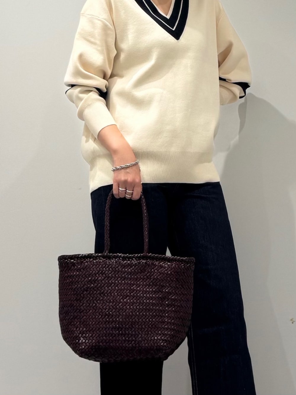 パープル系のトートバッグ、ブルー系のデニムパンツ、ブラック系のローファーを着用したレディースの冬コーディネートの7枚目の写真