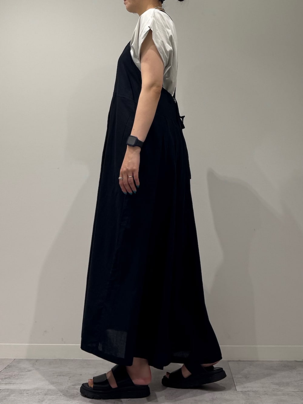 ブラック系のワンピース、ホワイト系のかごバッグ、ブラック系のサンダルを着用したレディースの夏コーディネートの5枚目の写真