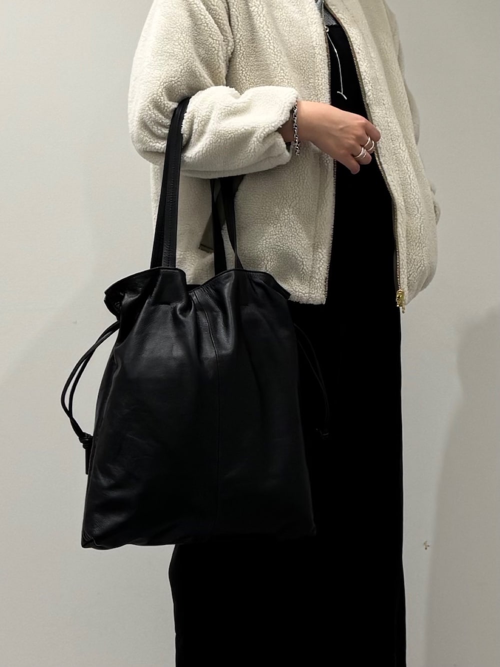 ブラック系のトートバッグ、ブラック系のサロペット/オーバーオール、ブラック系のローファーを着用したレディースの冬コーディネートの7枚目の写真