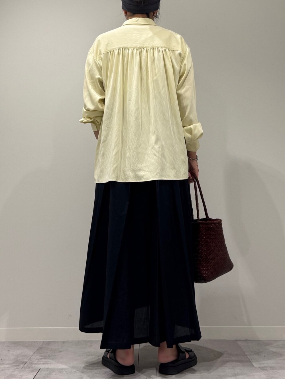 ブラウン系のトートバッグ、ブラック系のワンピース、イエロー系のシャツ/ブラウスを着用したレディースの秋コーディネートの3枚目の写真