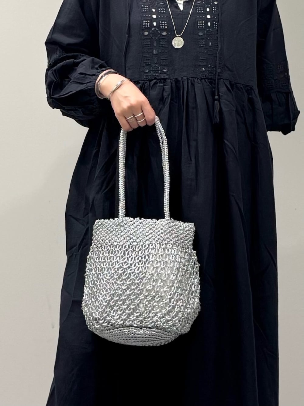 ブラック系のワンピース、シルバー系のかごバッグ、ブラック系のサンダルを着用したレディースの秋コーディネートの9枚目の写真