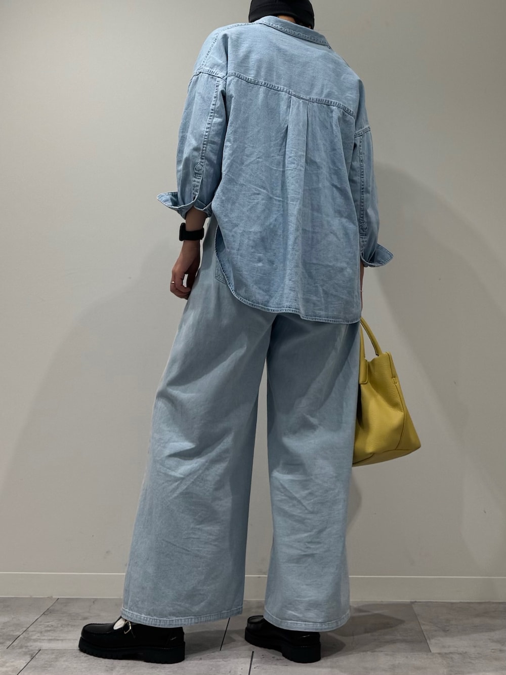 イエロー系のショルダーバッグ、ブルー系のデニムパンツ、ブラック系のローファーを着用したレディースの春コーディネートの4枚目の写真