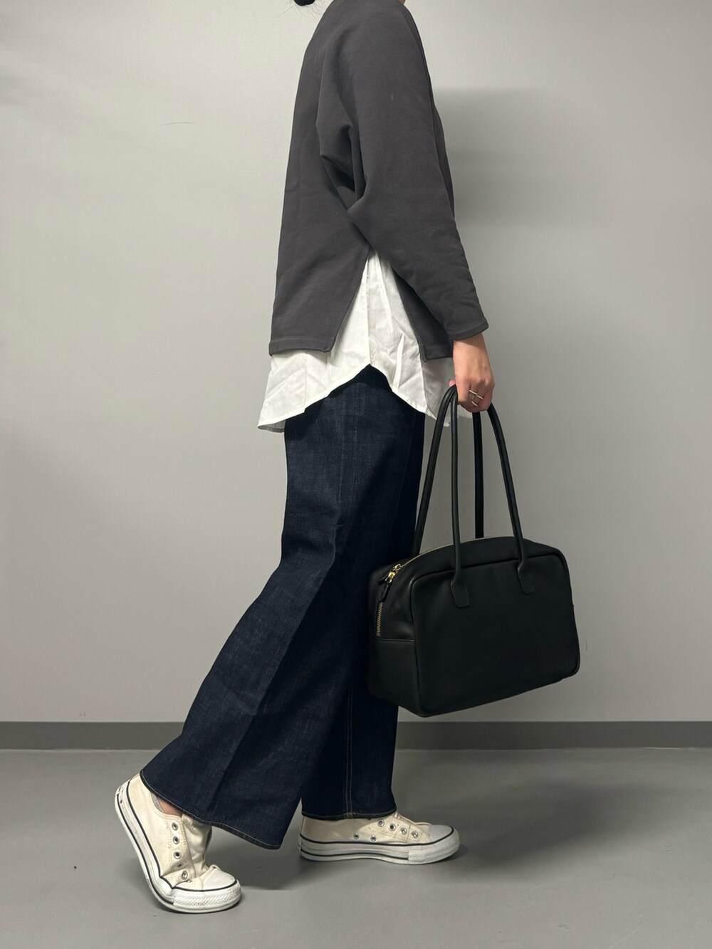 グレー系のスウェット、ブルー系のデニムパンツ、ブラック系のボストンバッグを着用したレディースの秋コーディネートの7枚目の写真