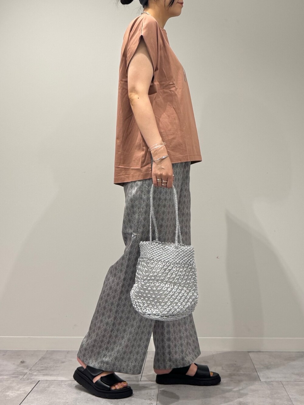 ピンク系のTシャツ/カットソー、シルバー系のかごバッグ、ベージュ系のその他パンツを着用したレディースの夏コーディネートの2枚目の写真