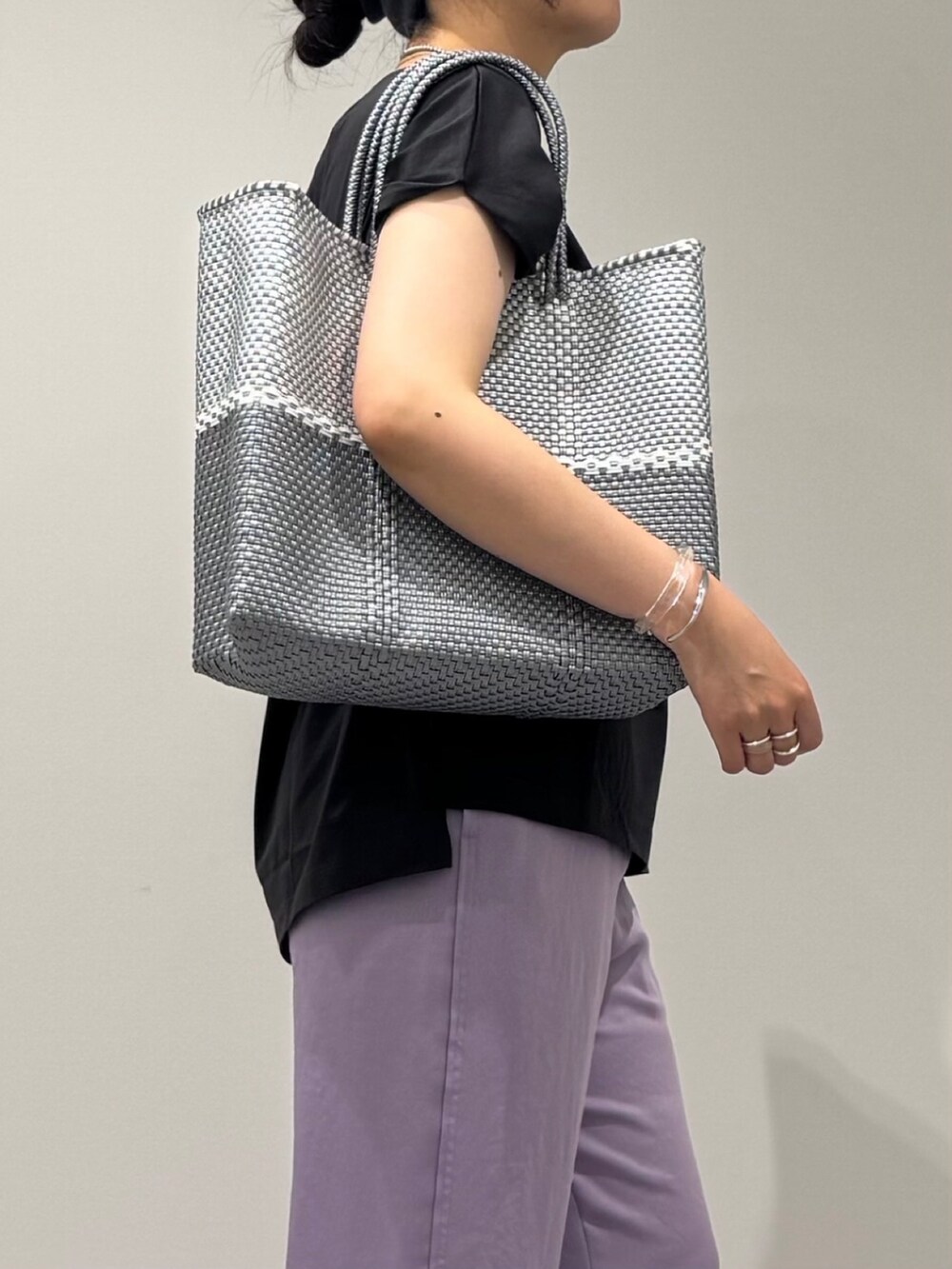 グレー系のTシャツ/カットソー、シルバー系のかごバッグ、ブラック系のサンダルを着用したレディースの夏コーディネートの8枚目の写真