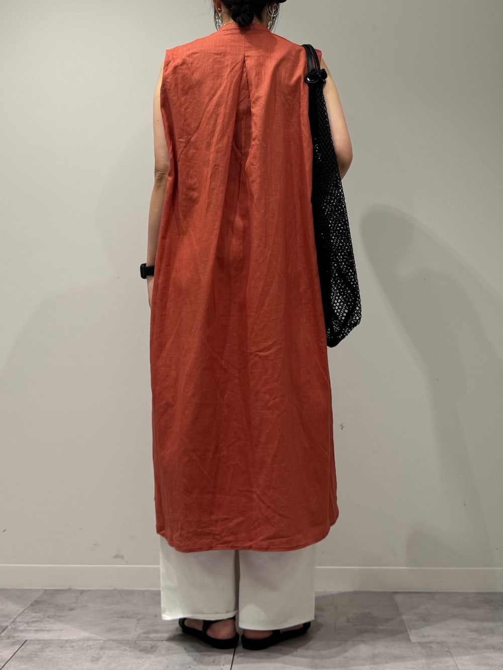 レッド系のワンピース、ホワイト系のデニムパンツ、ブラック系のサンダルを着用したレディースの夏コーディネートの3枚目の写真
