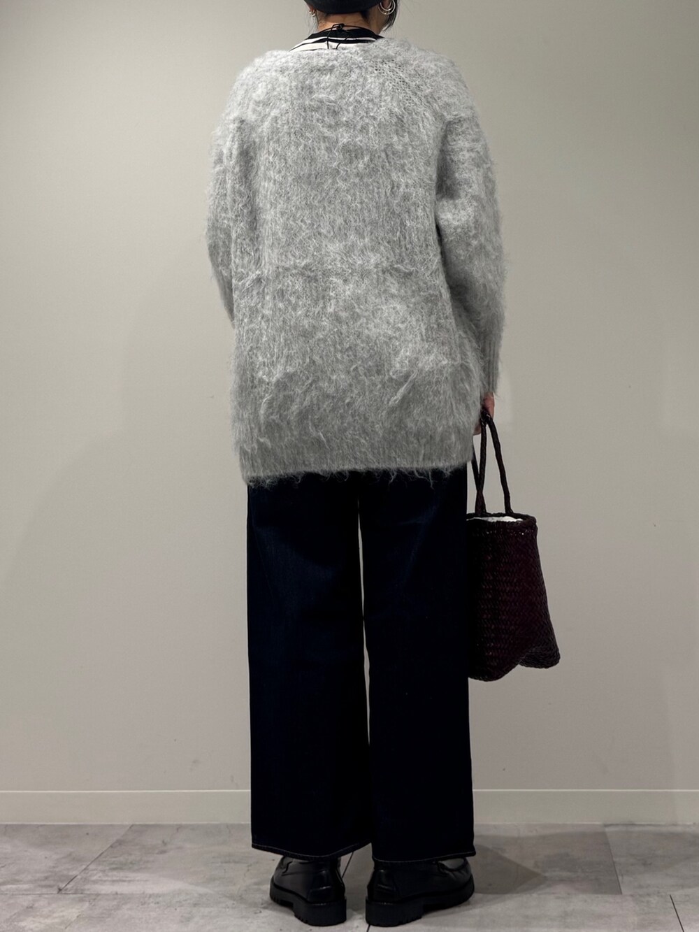 パープル系のトートバッグ、ブルー系のデニムパンツ、ブラック系のTシャツ/カットソーを着用したレディースの冬コーディネートの4枚目の写真