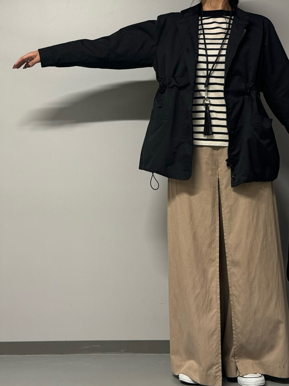 ブラック系のトートバッグ、ブラック系のブルゾン、ブラック系のTシャツ/カットソーを着用したレディースの秋コーディネートの2枚目の写真