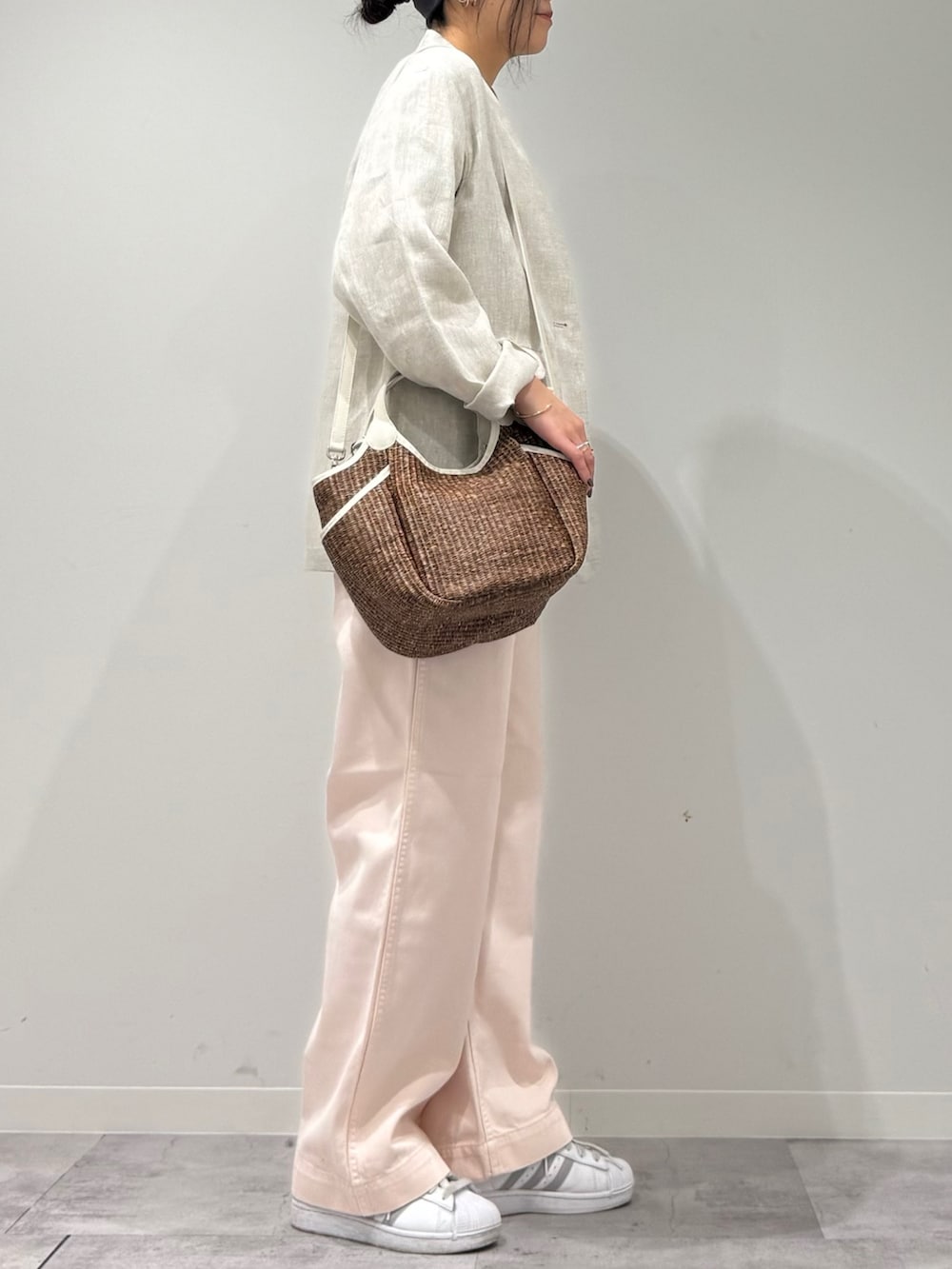 ピンク系のその他パンツ、ブラウン系のかごバッグ、ベージュ系のノーカラージャケットを着用したレディースの春コーディネートの2枚目の写真