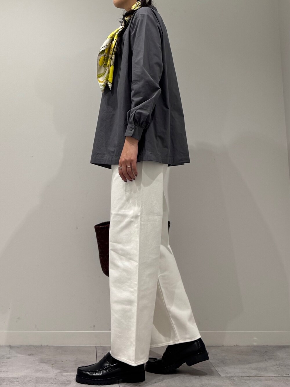 ブラウン系のトートバッグ、ホワイト系のデニムパンツ、ブラック系のローファーを着用したレディースの秋コーディネートの5枚目の写真